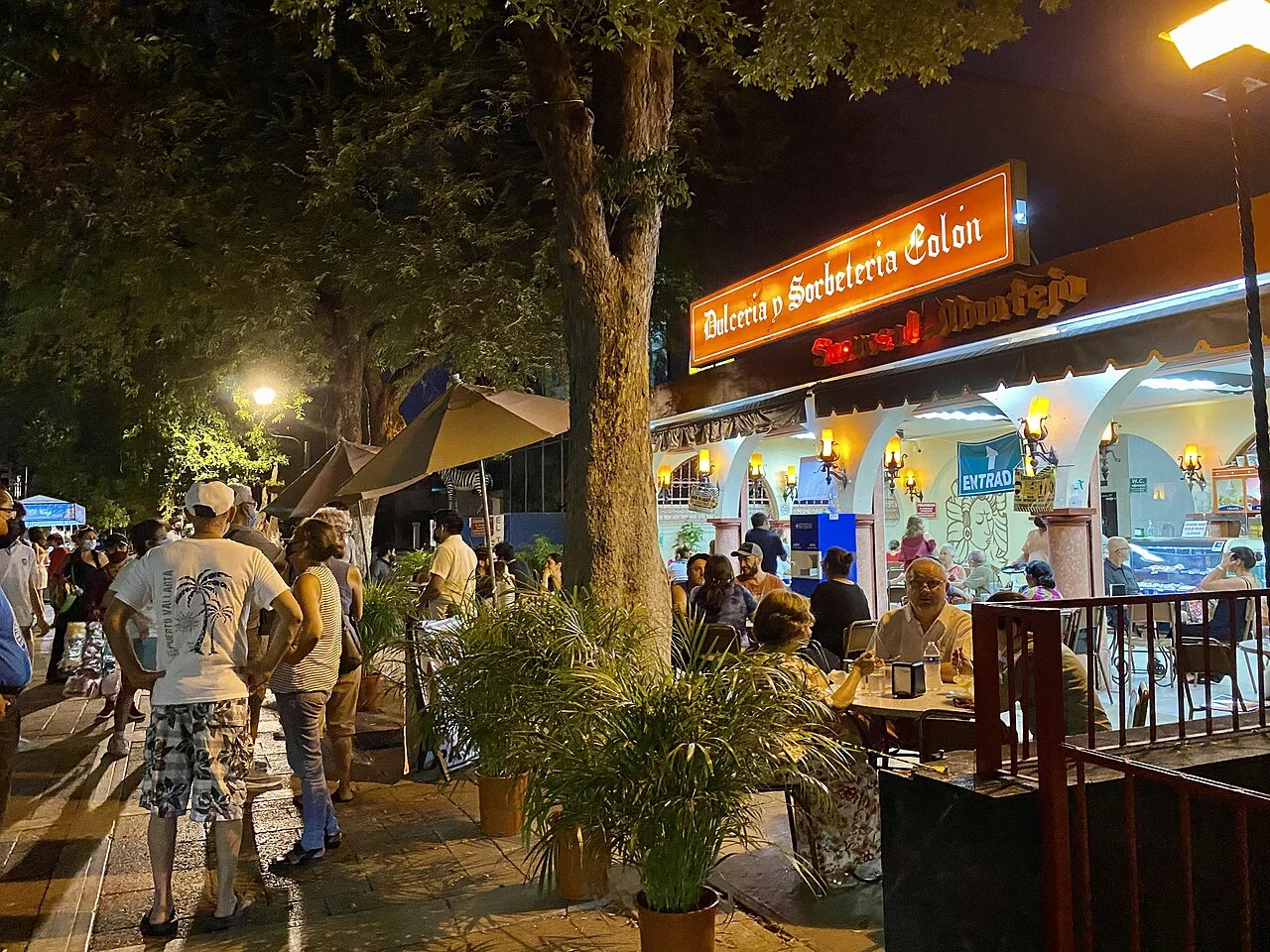 Terraza iluminada de la Dulcería y Sorbetería Colón en el Paseo de Montejo por la noche