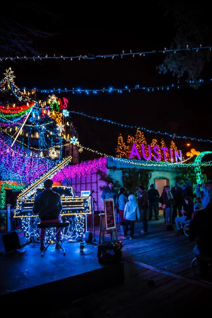 Terraza de café iluminada con luces frente al lago en Austin al anochecer