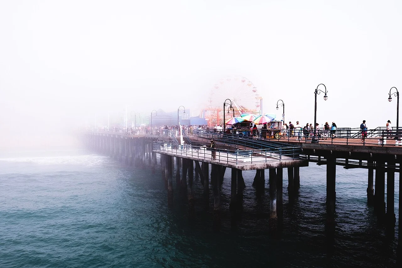 Muelle de Santa Mónica envuelto en neblina marina, con la rueda de la fortuna apenas visible
