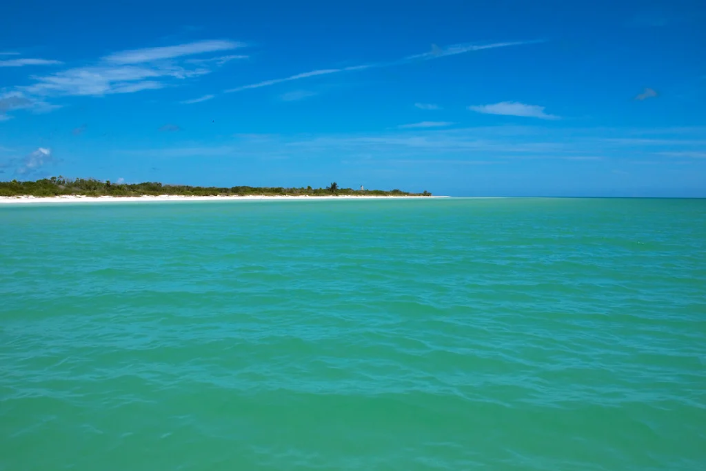 Aguas turquesa poco profundas frente a una franja de arena blanca en Punta Mosquito, Holbox
