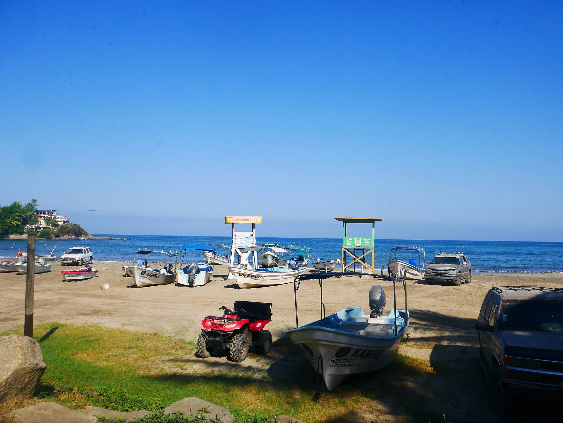 Lanchas de pescadores y torres de salvavidas en la arena de Playa Sayulita en una mañana despejada