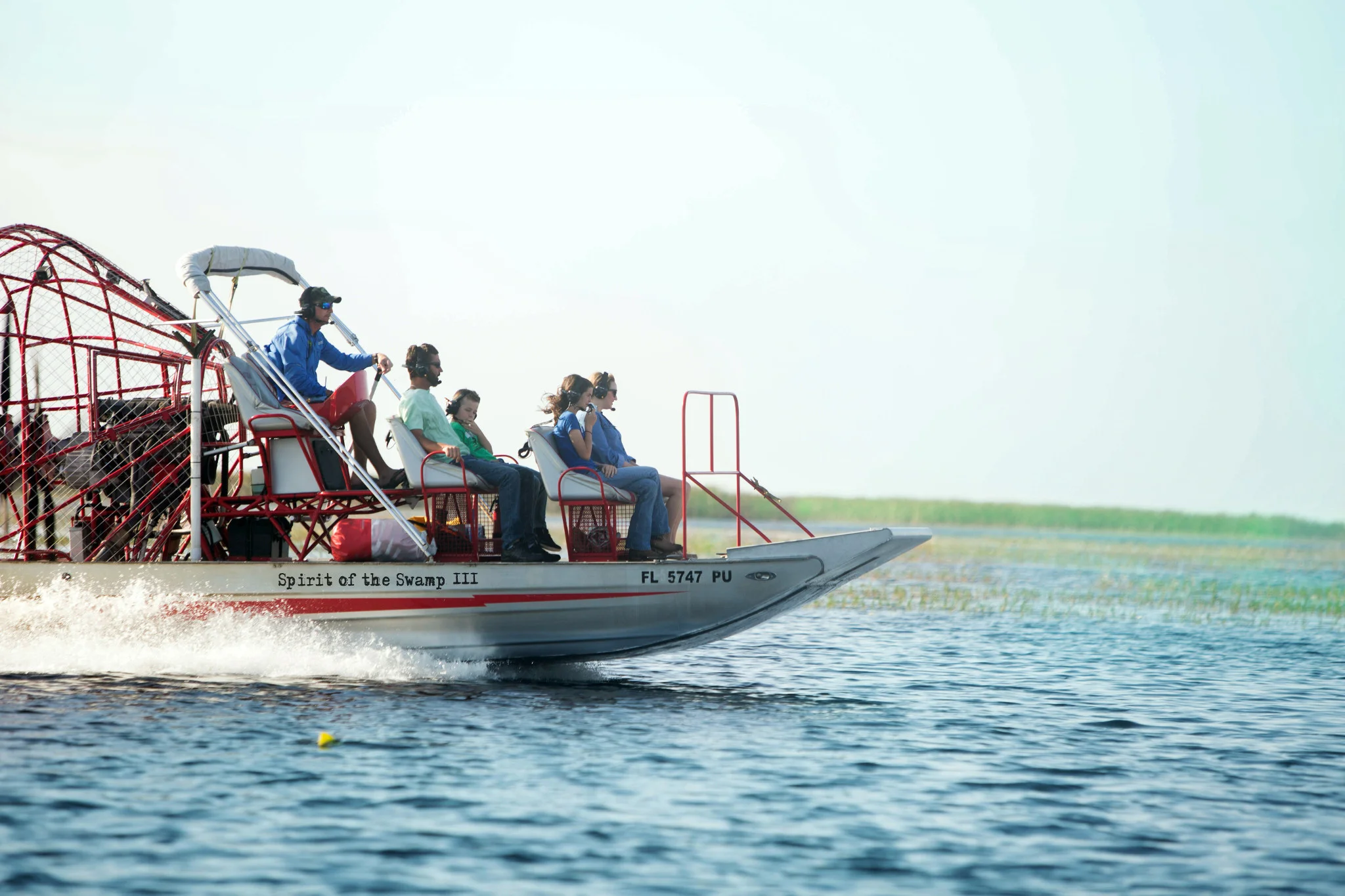 Familia a bordo de un hidrodeslizador que avanza a toda velocidad sobre un lago de Florida Central