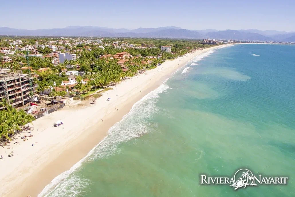 Vista aérea de una larga playa de arena dorada y agua turquesa en la Bahía de Banderas