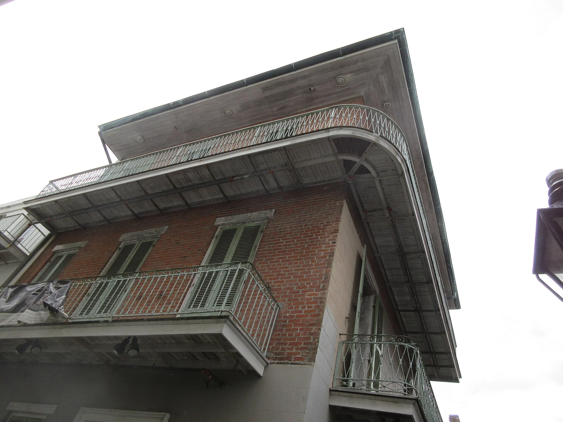 Edificio de ladrillo con balcones curvos de hierro forjado visto desde la calle