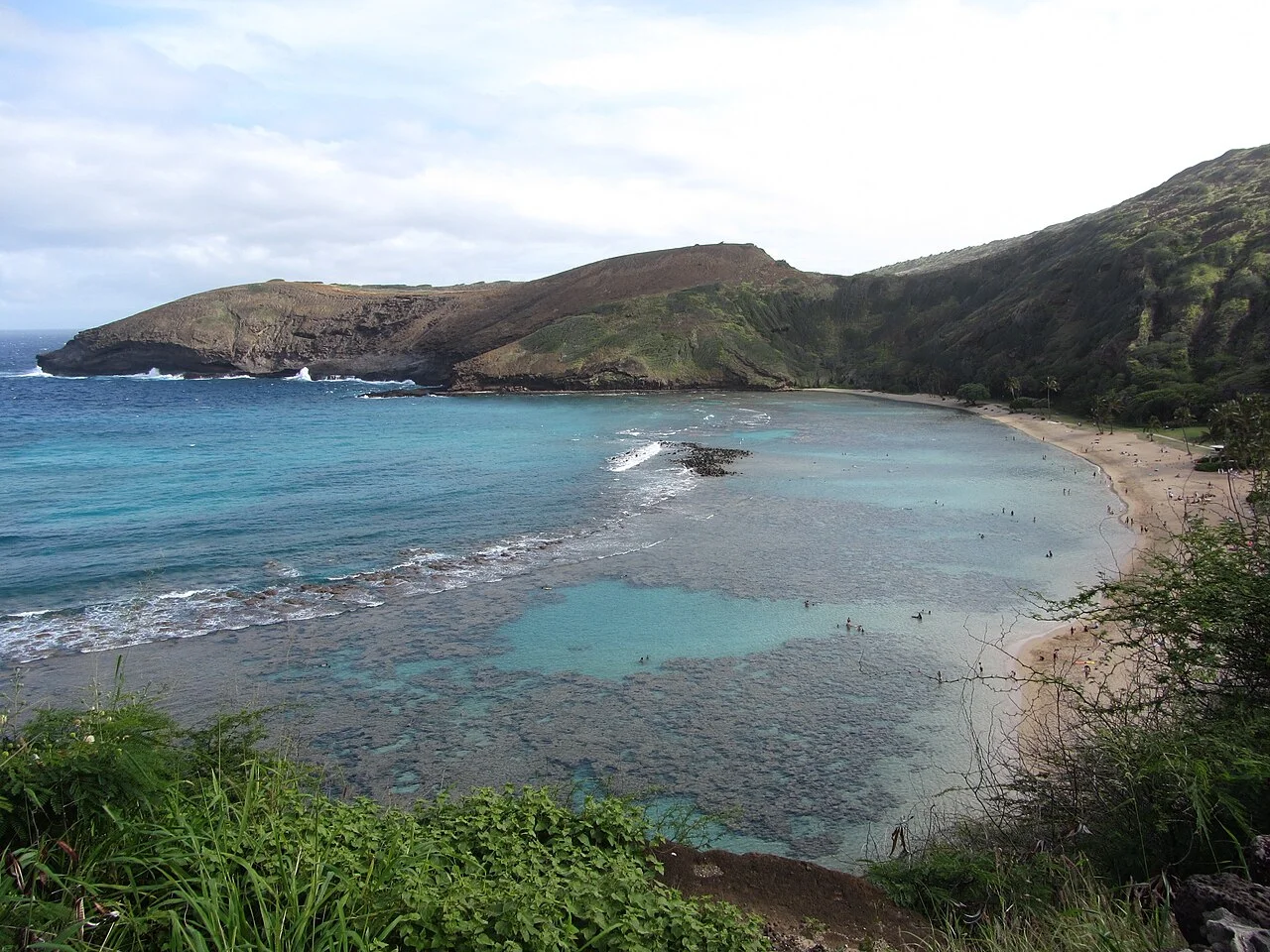 Arrecife de coral y aguas turquesa de Hanauma Bay rodeada por el antiguo cráter