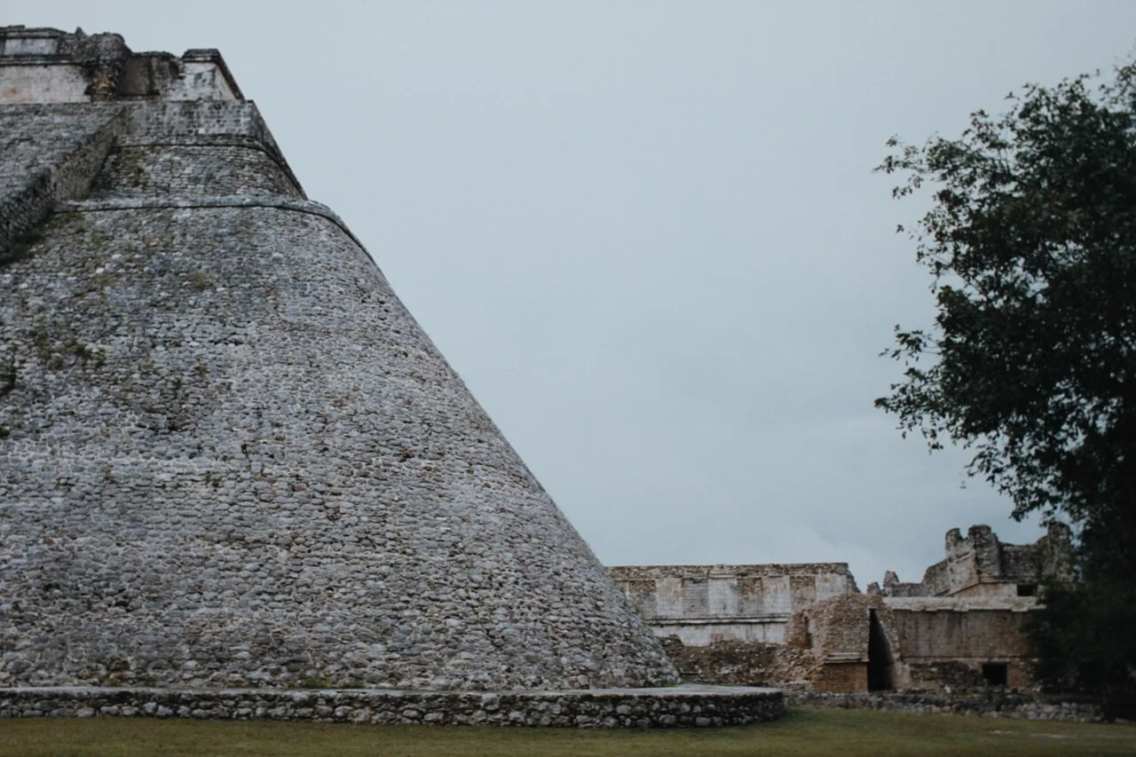 Pirámide del Adivino en la zona arqueológica de Uxmal, con edificios del Cuadrángulo al fondo