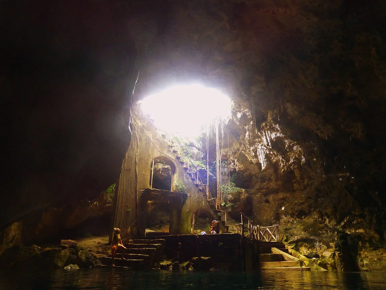 Cenote subterráneo de Cuzamá con un haz de luz que entra por la bóveda y escaleras hacia el agua