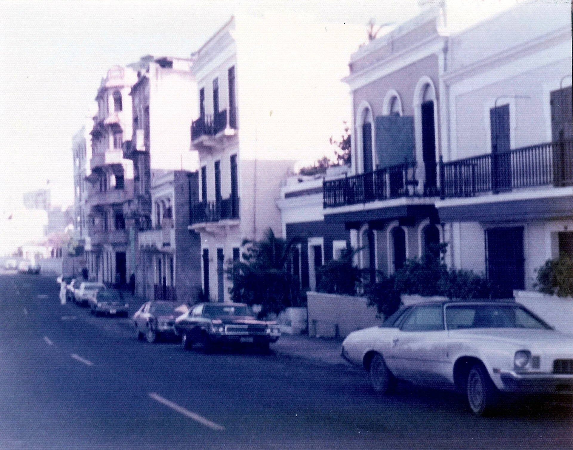 Fotografía antigua de una calle del Viejo San Juan con balcones y autos de los años setenta